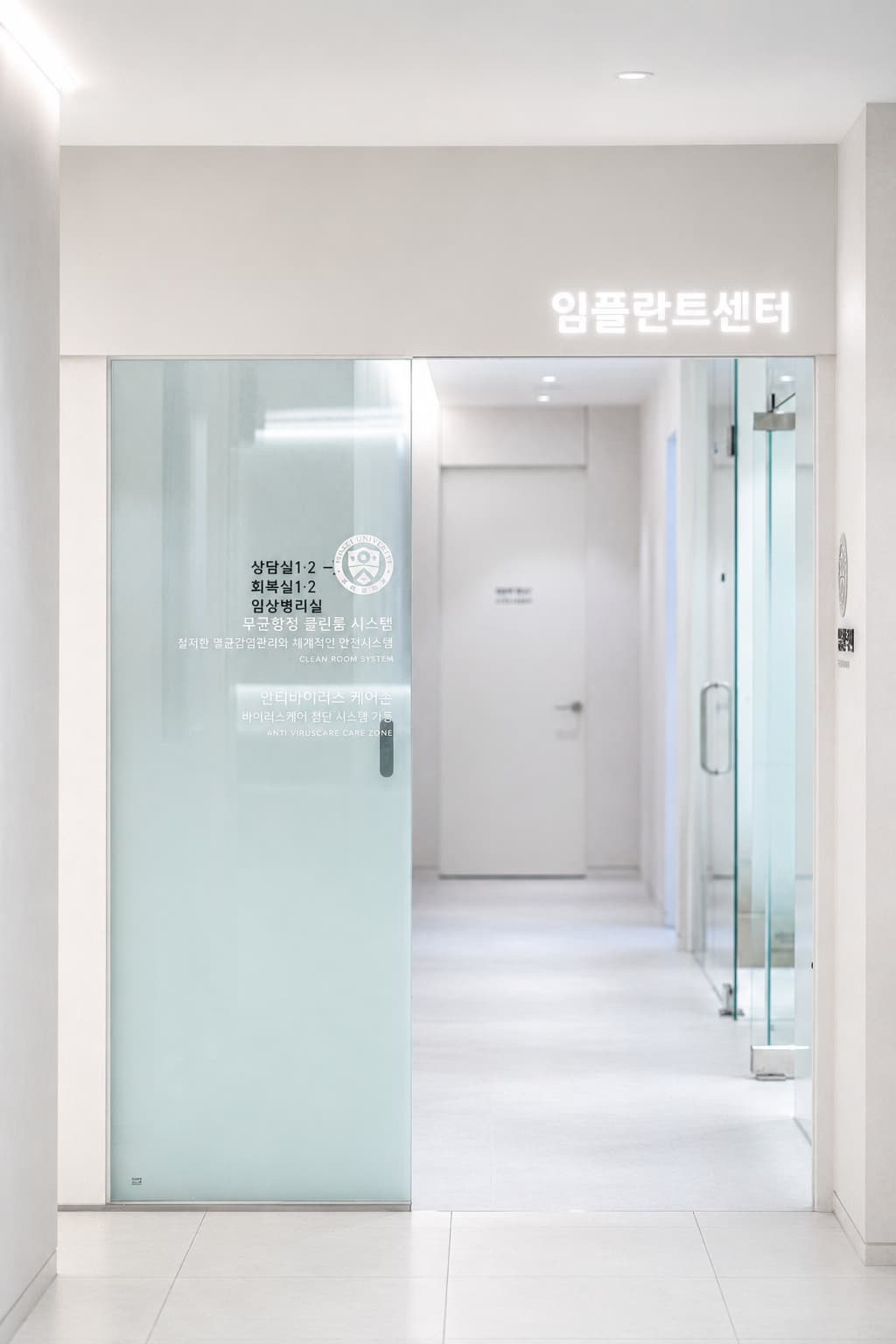 임플란트센터 입구. 유리문 위에 임플란트센터 사인이 켜져 있다